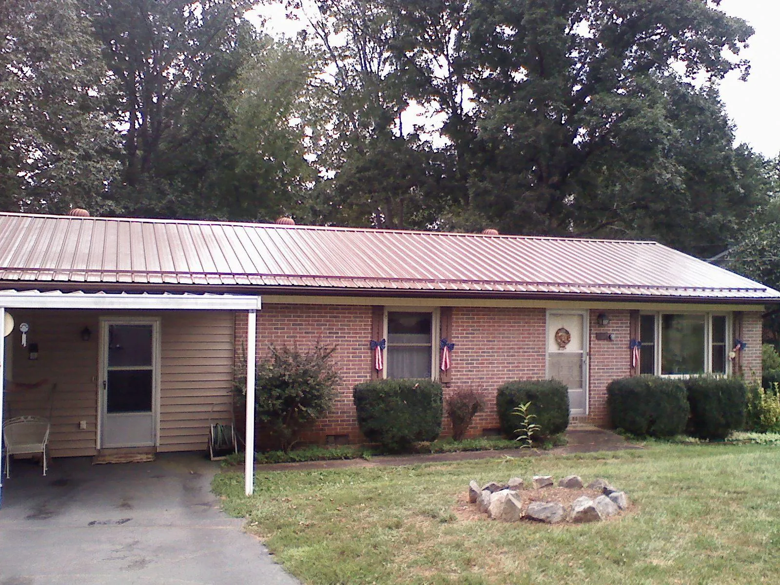 Bronze metal roof and carport on a brick ranch home — Roof Repair work by our crew in Penfield